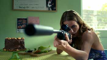 Film still of a woman with a gun