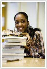Smiling woman leaning o n pile of books - Job Seekers information