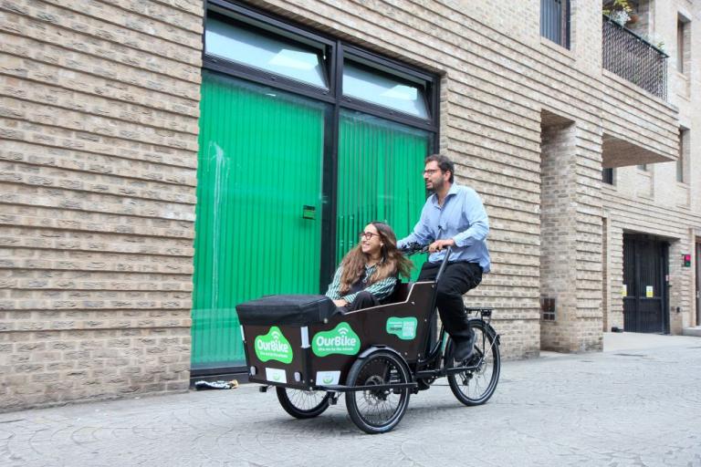 woman in an e-cargo bike, man riding the bike