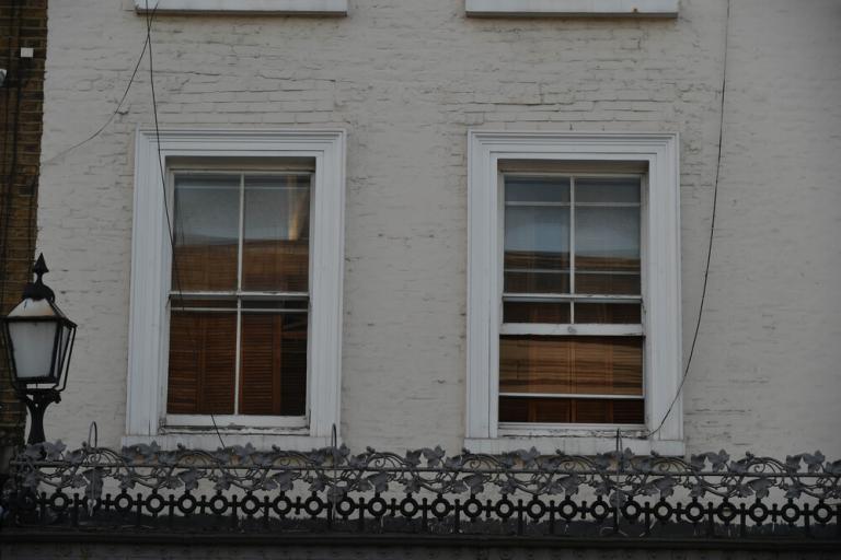 White building with two windows on an upper floor