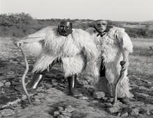 2 men in furry costume with tribal masks on.