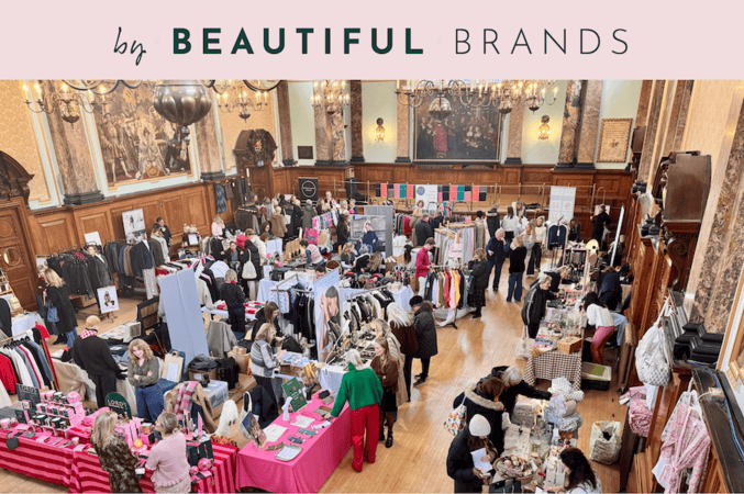 A busy indoor market with stalls selling clothes and accessories in a large, ornate hall