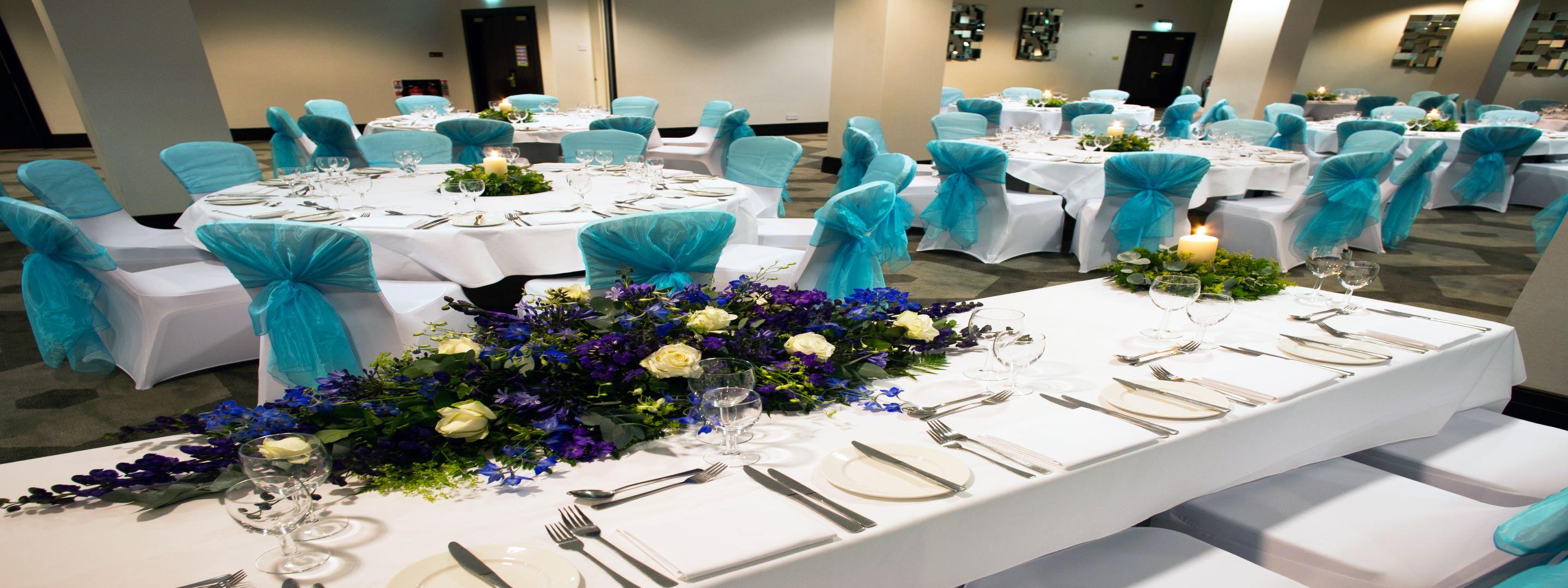 Inside of wedding venue with chairs and decorations laid out.