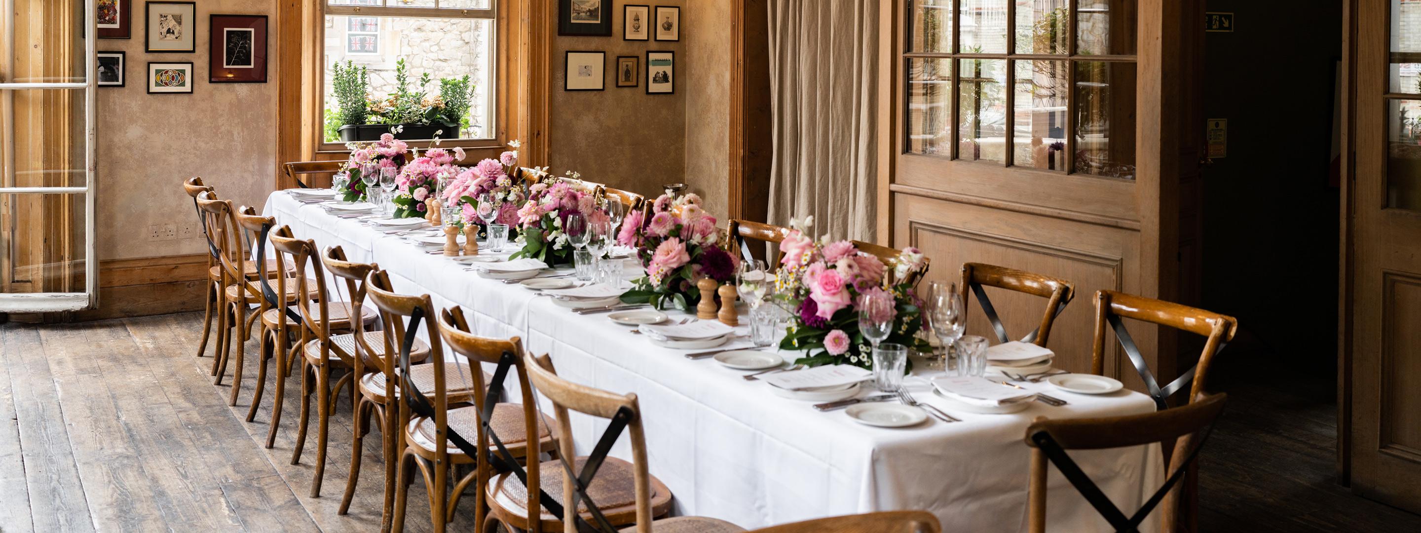 Dinner table set up with flowers, plates and cutlery