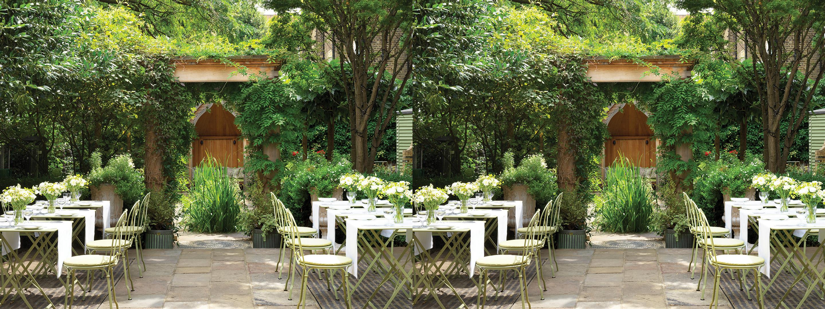 white chairs positioned in a flowery garden