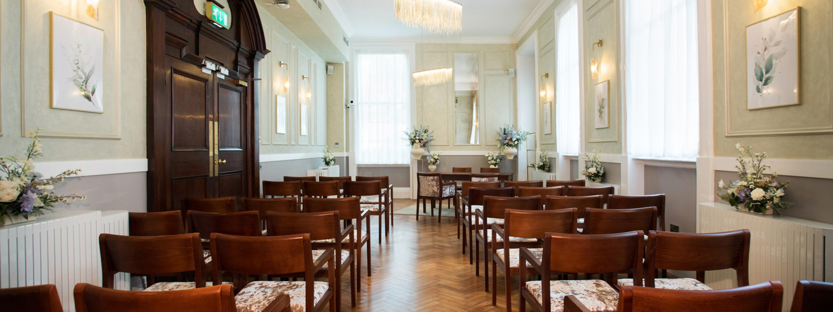 Rows of wooden chairs either side of the aisle in the Brydon room
