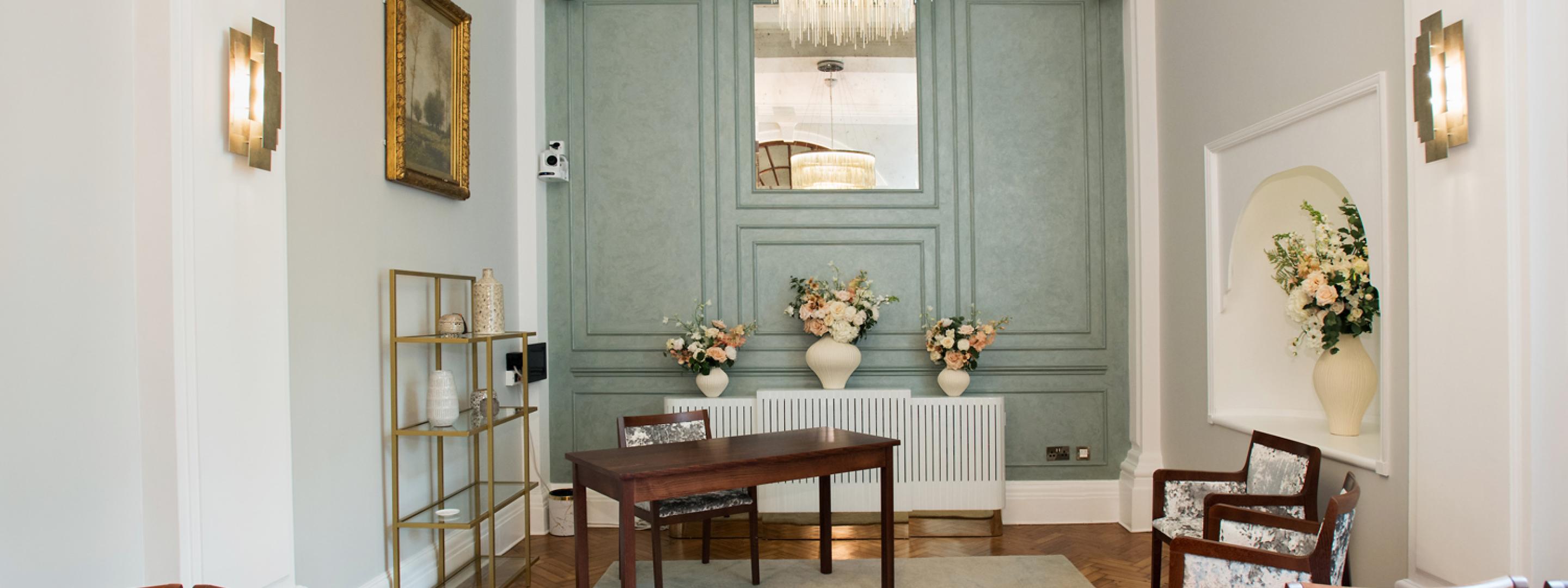 Mid distance view of Rossetti room showing wall panel and table and chairs.