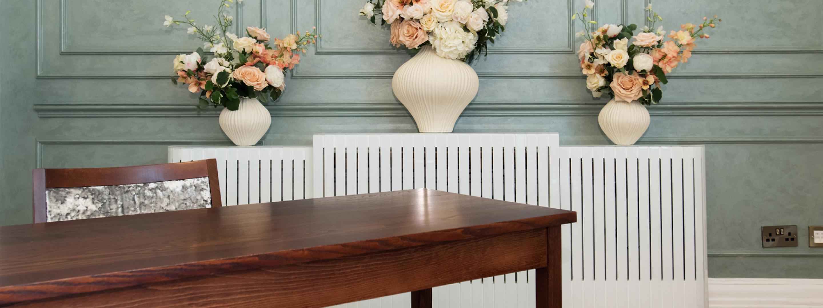 Close view of stylish radiator, floral display and feature wall in Rossetti room.