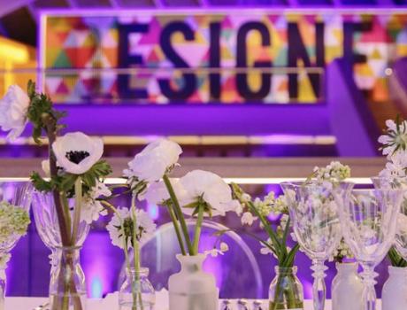 Wind glasses and flowers on dinner table with purple background