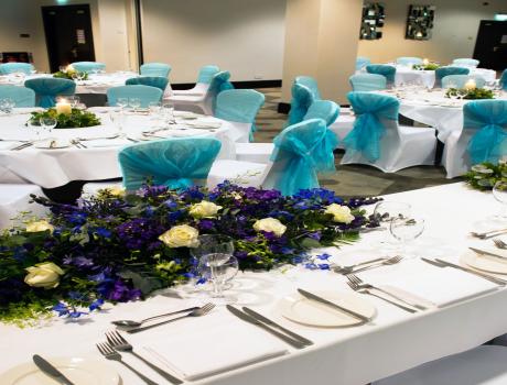 Inside of wedding venue with chairs and decorations laid out.