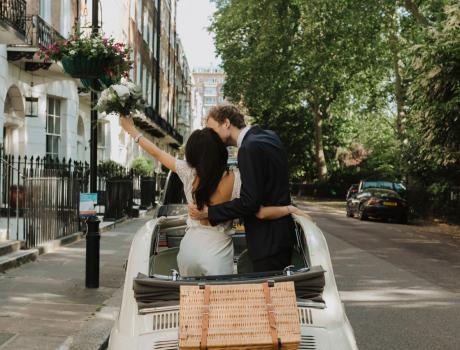 Couple standing through the sunroof of white car