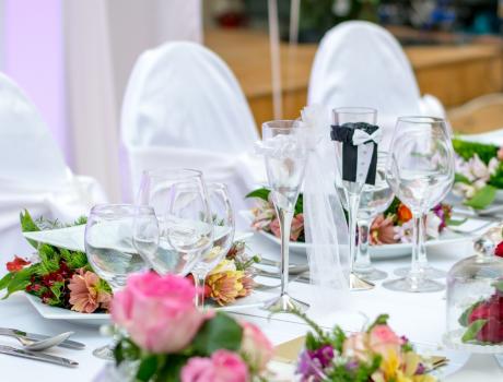 Table laid out for ceremony with flowers, balloons.