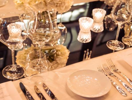 Plates, glasses and cutlery laid out on table