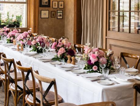 Dinner table set up with flowers, plates and cutlery