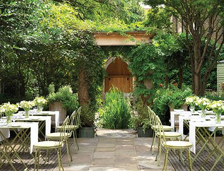 white chairs positioned in a flowery garden