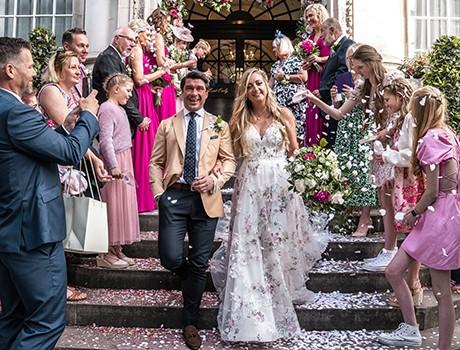 People wearing wedding clothes standing on the street