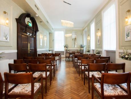 Rows of wooden chairs either side of the aisle in the Brydon room