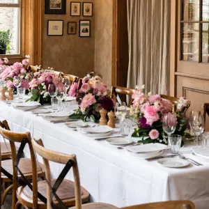 Dinner table set up with flowers, plates and cutlery