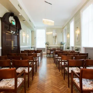Rows of wooden chairs either side of the aisle in the Brydon room