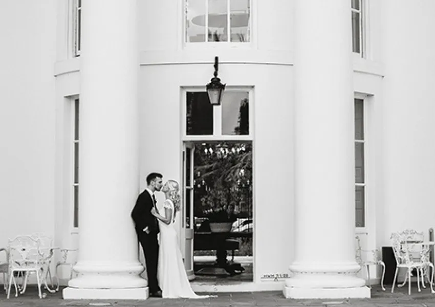 a couple outside a building with tall pillars