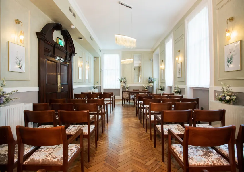 Rows of wooden chairs either side of the aisle in the Brydon room