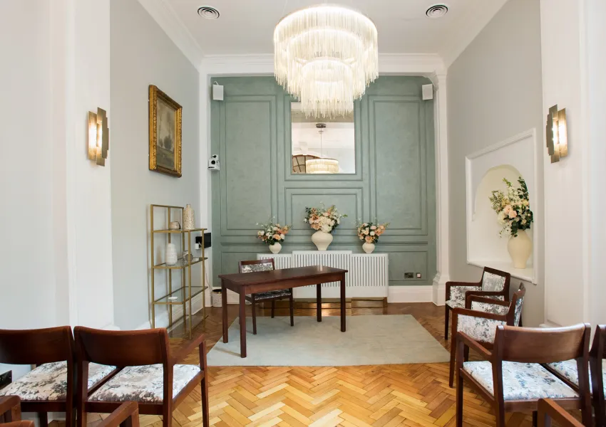 Mid distance view of Rossetti room showing wall panel and table and chairs.