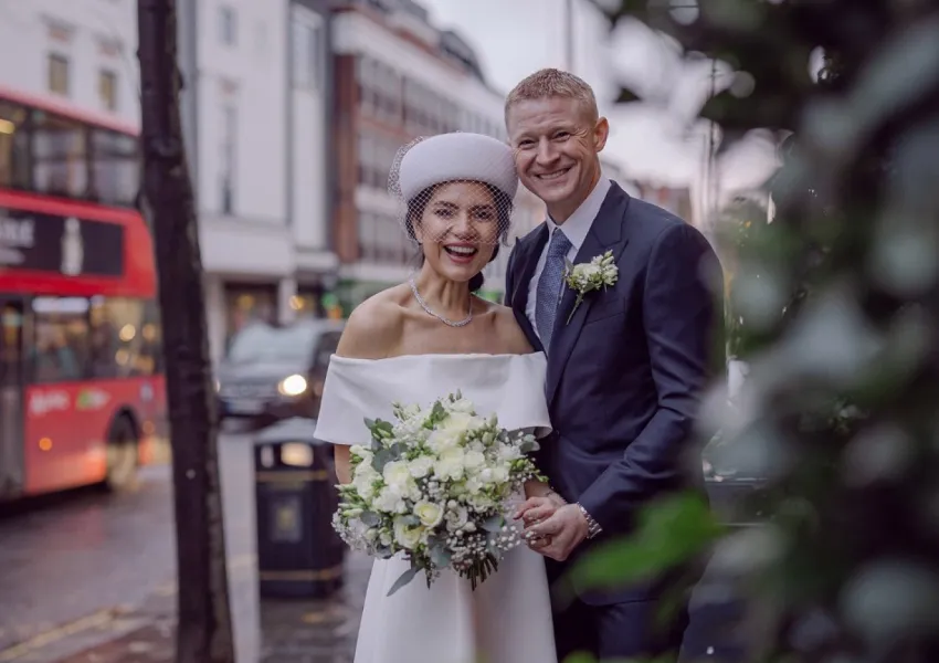 A bride and groom posing in the street