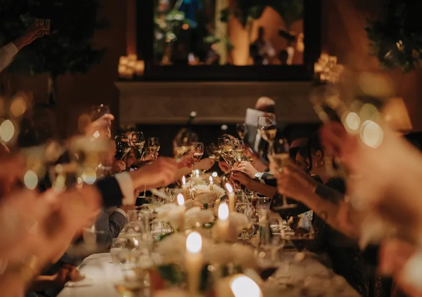 Guests clinking glasses over a dressed table