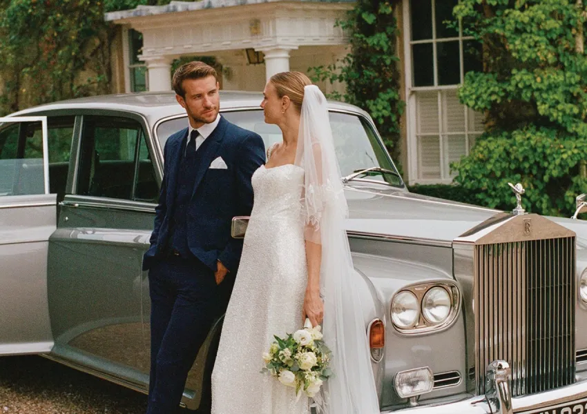 A wedding couple in a prestige car