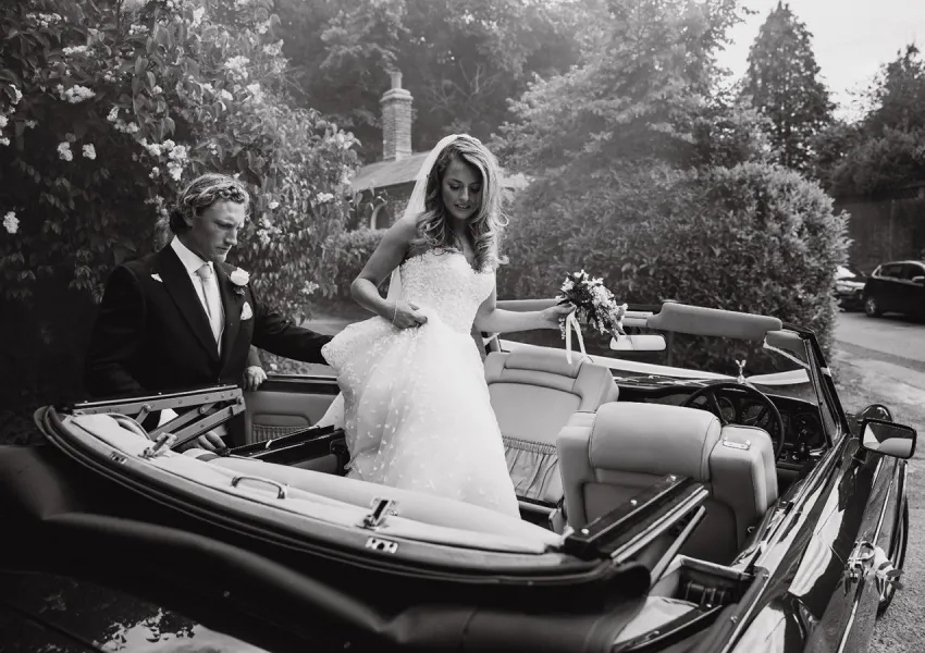 A wedding couple in a prestige car