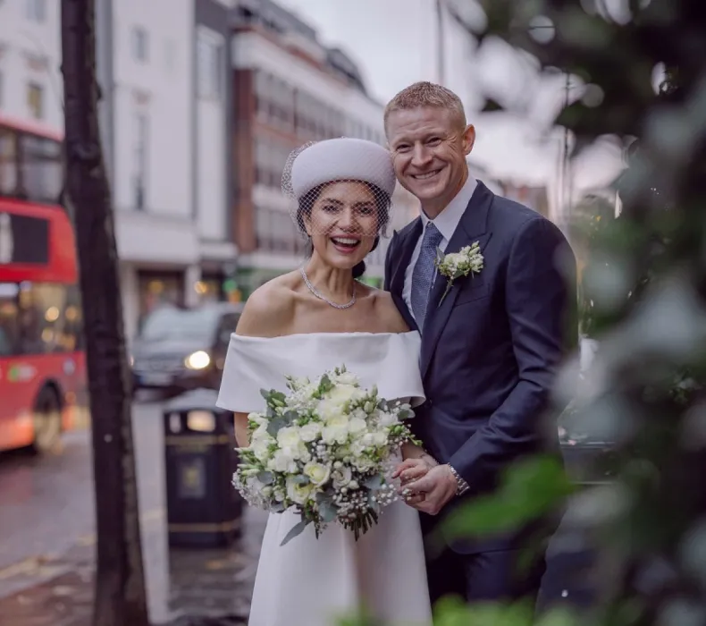 A bride and groom posing in the street