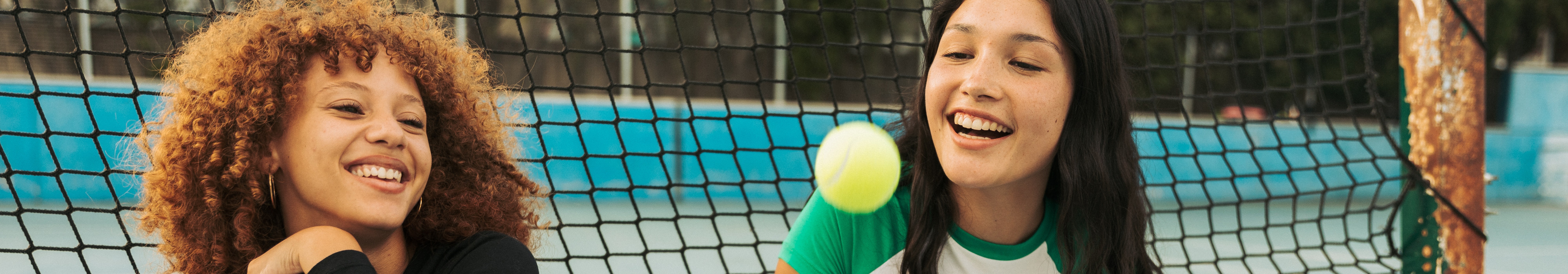  a group young girls smiling on a tennis court