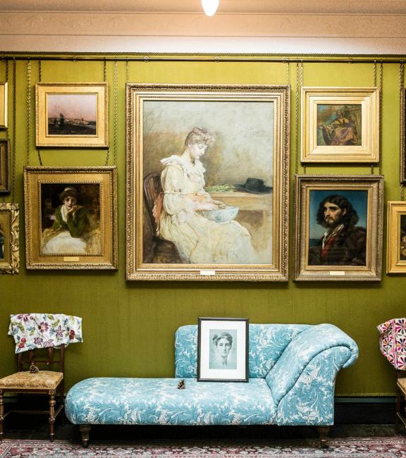 A room in Leighton House with a display of paintings and drawings