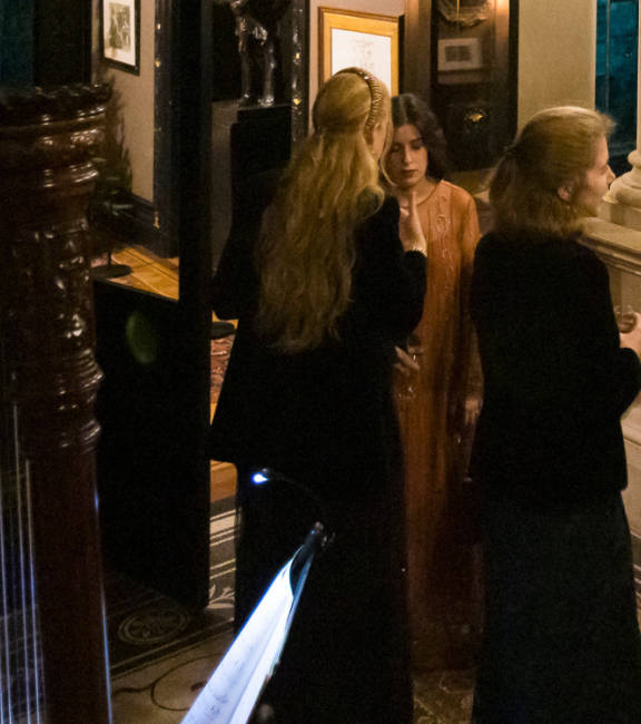 A musician and a group of people in the staircase hall at Leighton House