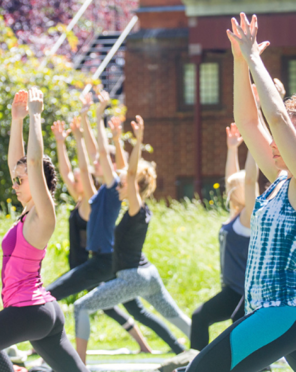 A group of women practising yoga in the gardens of Leighton House