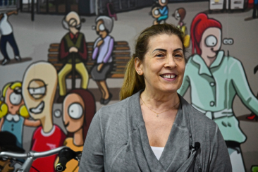 Smiling woman standing in front of a colourful mural