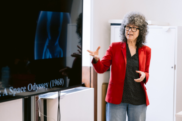 Image of woman standing and pointing at screen