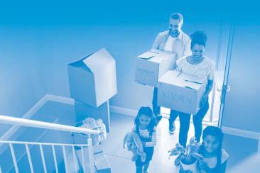 A happy young family carrying boxes as they move in