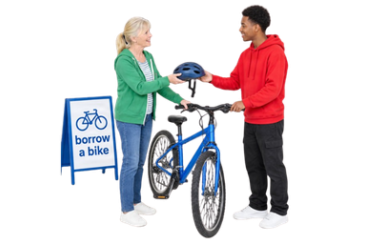 A person borrowing a bicycle and receiving a helmet from another person beside a ‘borrow a bike’ sign.