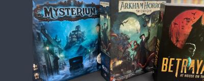 A close-up shot of 3 games, Mysterium, Arkham Horror, and Betrayal