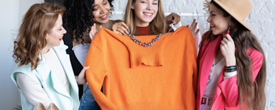 Group of women admiring an orange jumper