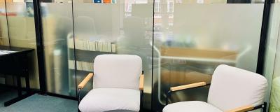 Two chairs and an empty table in a small room.