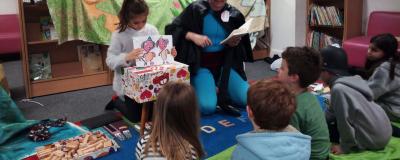 children sitting on a mat reading a story