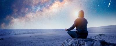 Person doing a yoga pose under the night sky