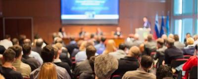Image of audience in conference hall listening to a presentation