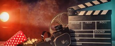 A picture of a camera, a flim clapperboard, film cannister and popcorn