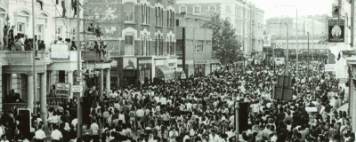 Black-and-white photograph of a densely packed street during a large public event or festival