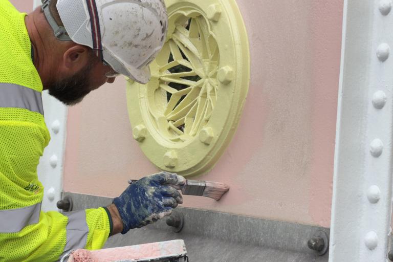 A worker paints Albert Bridge