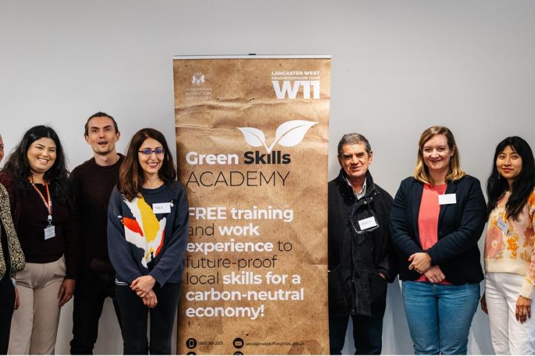 seven students stand beside a pull-up banner
