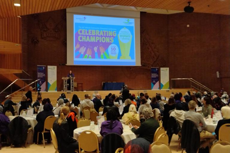 People sat at tables at community champions annual conference